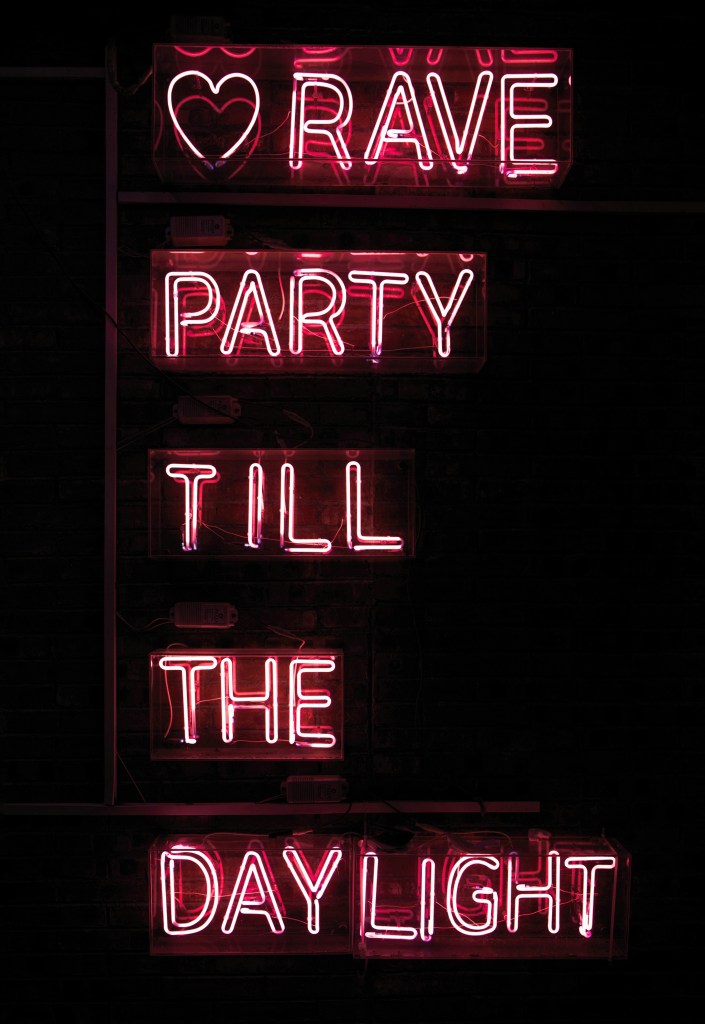 Image: red neon sign lit up in the dark reading "rave party till the daylight" with a heart before the words